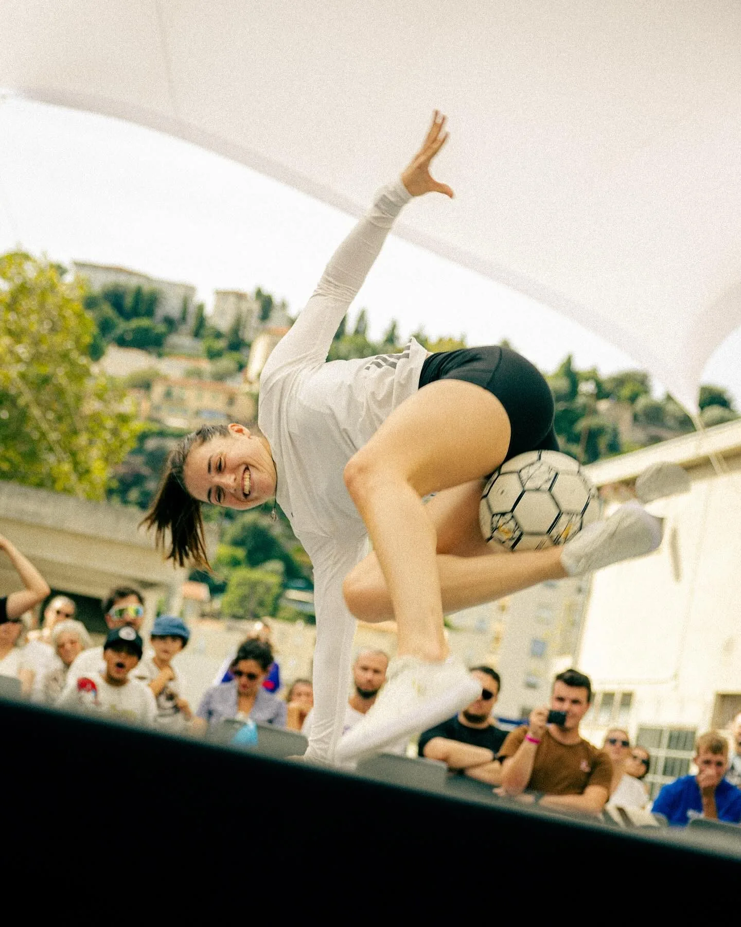 Yoanna Dallier en vol, le ballon bloqué entre les jambes, devant le public