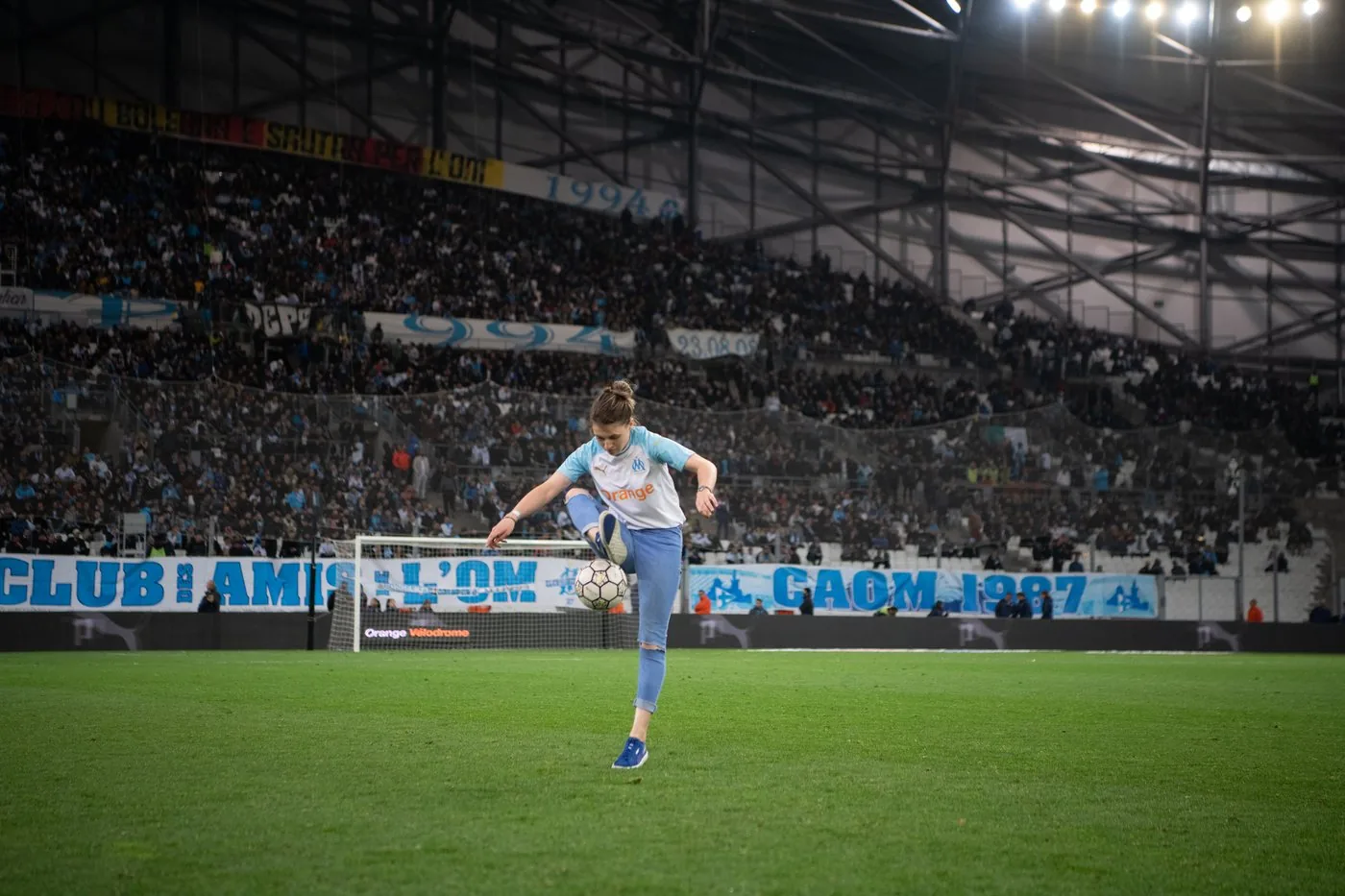 Yoanna Dallier en jonglage sur la pelouse de l'Orange Vélodrome, maillot de l'OM, devant les tribunes